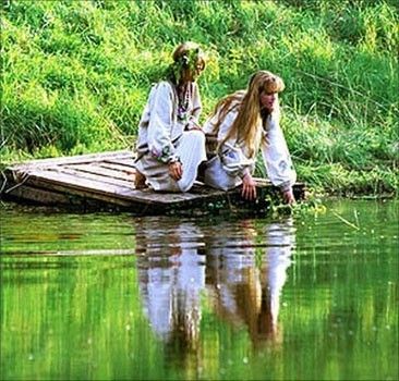 Девушки опускают в воду венки